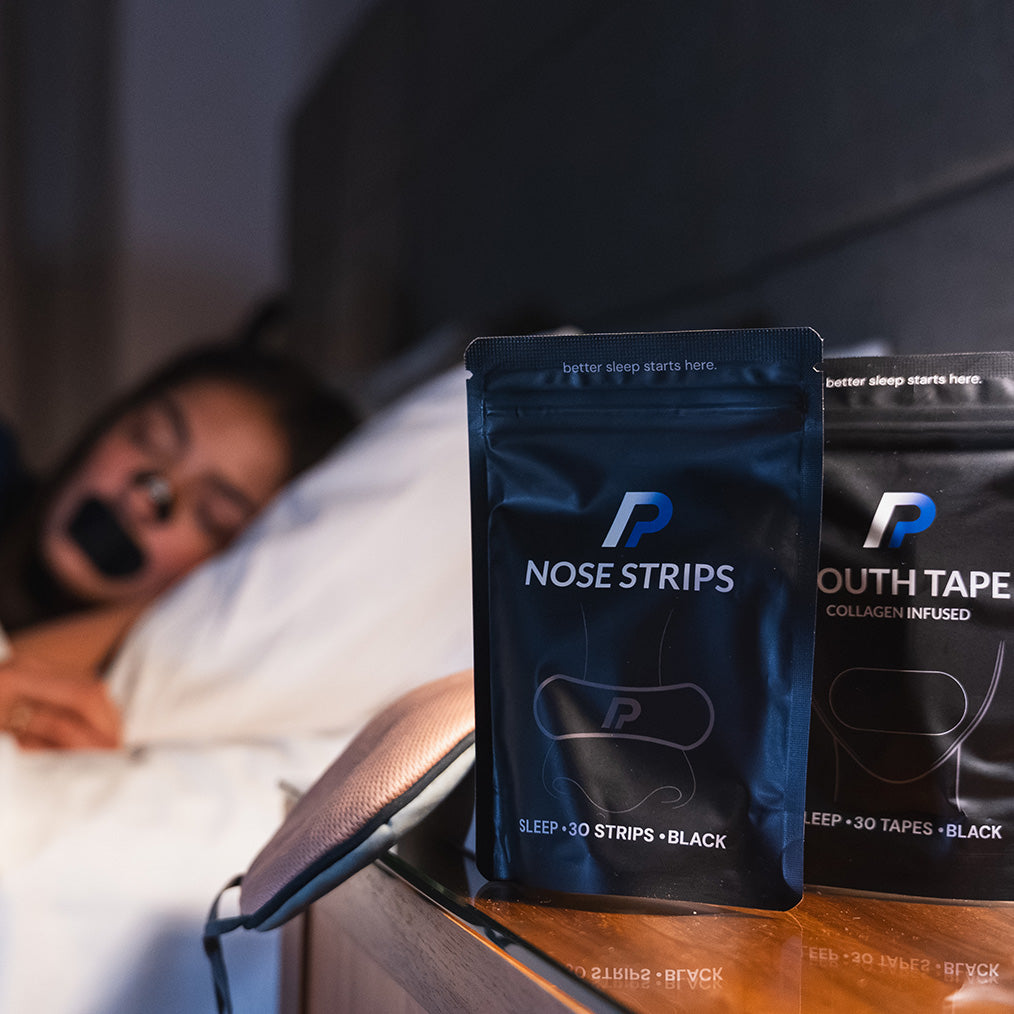 Woman lying in bed with nose strips and mouth tape packs on a bedside table