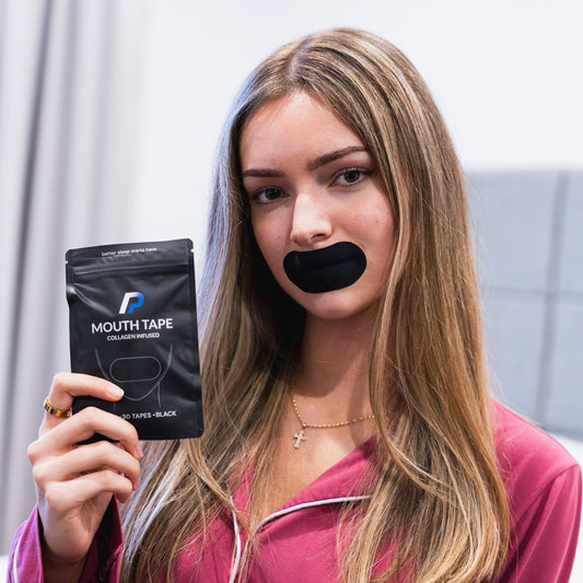 Woman holding a mouth tape pack while wearing black mouth tape